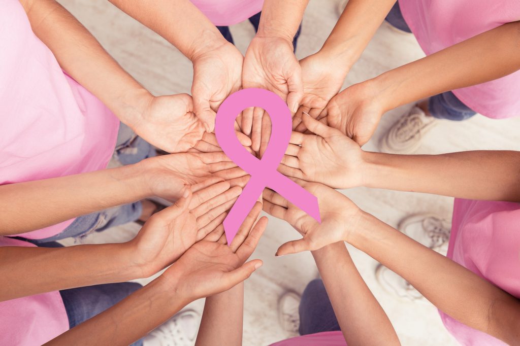 Women Hands Holding Pink Breast Cancer Ribbon Standing Together