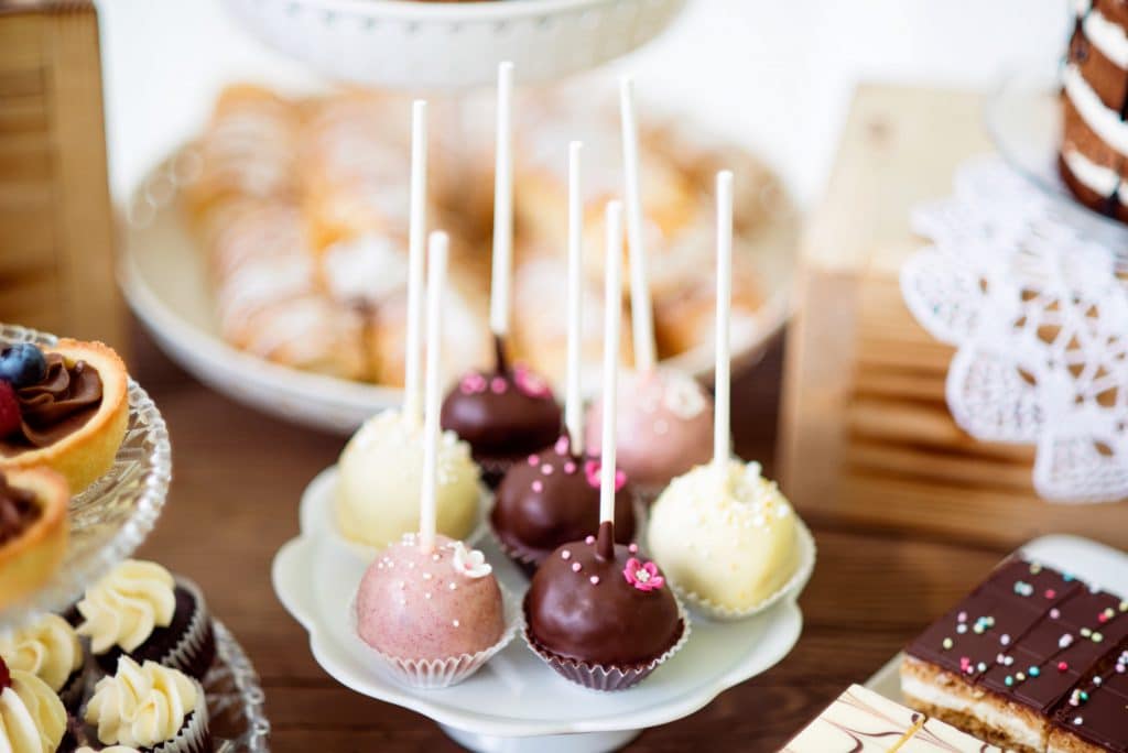 Cake pops on cakestand, tarts and cupcakes. Candy bar.