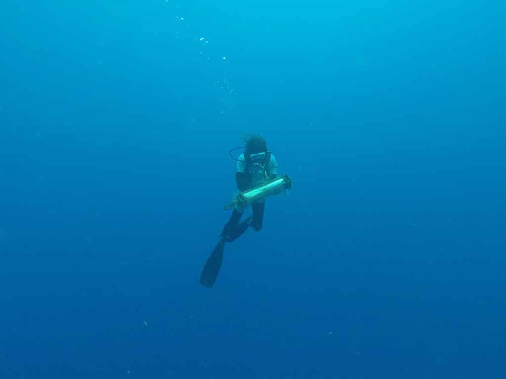 Sous l'eau, Julien de l'association Tité remontant l'hydrophone à la surface. Photo de Thibaud Rossard Ommag.